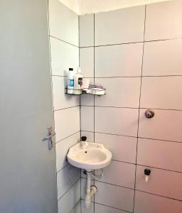 une salle de bain avec un lavabo dans un mur carrelé dans l'établissement Sunny Escape, à Mtwapa