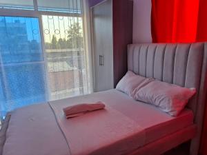 un lit avec un oreiller rose et une fenêtre dans l'établissement Sunny Escape, à Mtwapa