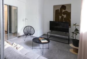 a living room with a couch and a tv and a table at Central Urban Retreat in Athens