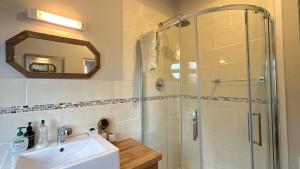 Un baño con lavabo y ducha de cristal. en The Residence Renvyle, en Gowlaun 47 fotos más