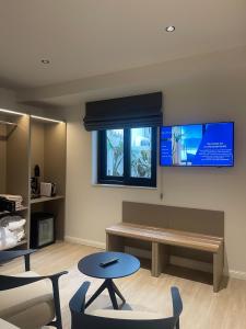 Una sala de espera con un banco y un televisor. en R Lapsi Guesthouse, en Siġġiewi 57 fotos más