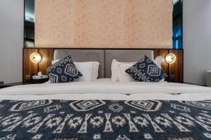 a bedroom with a large bed with pillows at Jovan suites apartment in AlUla