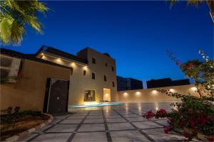 a villa with a courtyard at night at Jovan suites apartment in AlUla