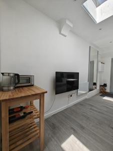 ein Wohnzimmer mit einem Flachbildfernseher an der Wand in der Unterkunft Skylit Studio Retreat in Norwood