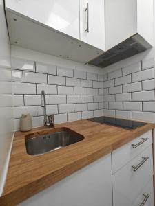 eine Küche mit einem Waschbecken und einer Arbeitsfläche aus Holz in der Unterkunft Skylit Studio Retreat in Norwood