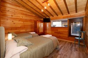 two beds in a room with wooden walls at El rincón de rosina in Sequera de Fresno