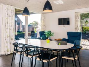 a dining room with a white table and chairs at Exclusive Golf View Retreat in Rømø Kirkeby