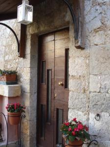 una porta di legno sul lato di un edificio con fiori di Agriturismo La Fattoria a San Donato Val di Comino