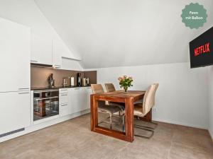 una cucina con tavolo e sedie in legno di Ferienhausträume-Bodensee Bergstrassen Apartments a Kreuzlingen