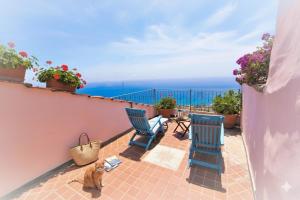 a cat sitting on a balcony looking at the ocean at da Patrick in Costarainera