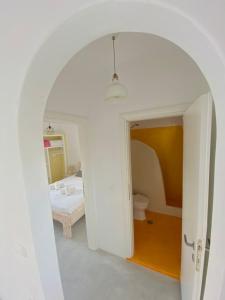 une voûte dans une chambre avec un lit et une salle de bains dans l'établissement Deluxe Apartment - Vlichada Beach, à Santorini