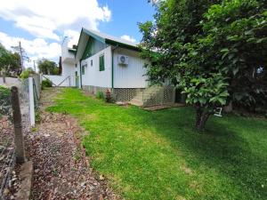 una casa con techo verde y patio en Casa Sander Gramado, en Gramado