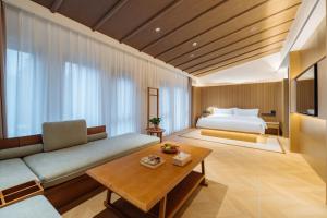 une chambre d'hôtel avec un lit et un canapé dans l'établissement Huazhu Luxury Niushou Yinlan Homestay, à Sanbanqiao