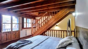 ein Schlafzimmer mit einem Bett und einer Holztreppe in der Unterkunft Casa vacacional El Rincón de Soto in Soto de Cangas