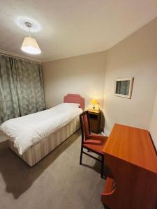 a bedroom with a bed and a desk and a table at The little flowers home in Salisbury