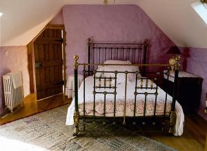 ein Schlafzimmer mit einem Bett und einer lila Wand in der Unterkunft Moongate lodge in Killedmond