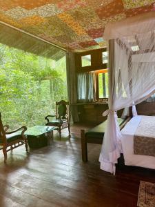 ein Schlafzimmer mit einem Bett und einer Decke mit Blumen in der Unterkunft Wild Monkey Jungle Villa - 4 Bedroom Villa in Unawatuna