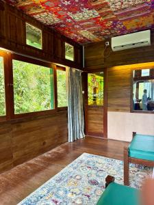 ein Wohnzimmer mit Holzvertäfelung und einer Decke mit Fenstern in der Unterkunft Wild Monkey Jungle Villa - 4 Bedroom Villa in Unawatuna