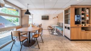 a dining room with tables and chairs and a tv at Premiere Classe Bourges in Bourges +16 photos