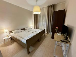 a bedroom with a bed and a table with a laptop at Pensiunea LAZY in Şelimbăr