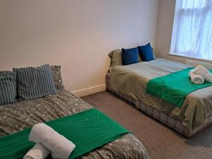 a bedroom with two beds and a window at Cosy 2 Bedroom Luxury House in Wednesbury