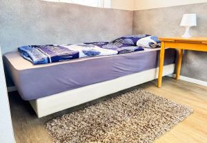 a bed in a room with a table and a rug at Studioappartement voor 2 personen - 33-43 in Bunkenburg +4 photos