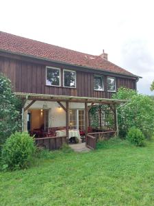 a large wooden house with a large porch at Domus Campus Latus - Ferienwohnungen Breitenfeld in Gumtow