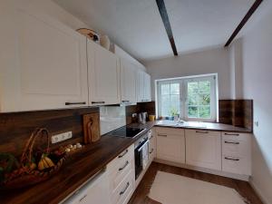 a kitchen with white cabinets and a window at Domus Campus Latus - Ferienwohnungen Breitenfeld in Gumtow