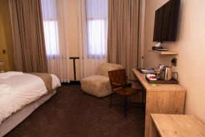 ein Hotelzimmer mit Bett und Schreibtisch in der Unterkunft Waterfront Guest House in Lüderitz + 71 Fotos