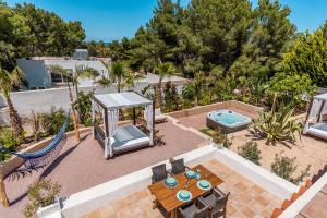 eine Außenterrasse mit einem Tisch, Stühlen und einer Schaukel in der Unterkunft Sunset lover Cala Comte/ Cala Tarida/ Cala Bassa in San Jose de sa Talaia