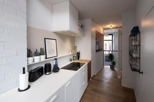 a kitchen with white cabinets and a sink at Townhouse Tongeren Center 275m2, 10p - Featured in Designbook in Tongeren