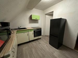 eine Küche mit einem schwarzen Kühlschrank im Zimmer in der Unterkunft Exclusive Monteursunterkunft in Wunsiedel