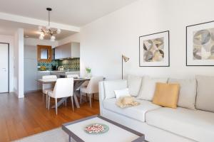 ein Wohnzimmer mit einer weißen Couch und einem Tisch in der Unterkunft Portopiccolo Apartments in Sistiana