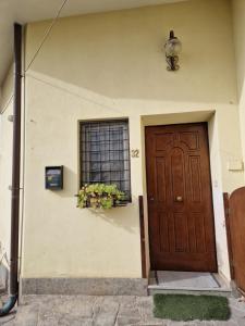 une maison avec une porte marron et une fenêtre dans l'établissement Casa butterfly Sacrofano, à Sacrofano