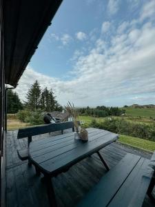 ein Picknicktisch auf einer Terrasse mit Blick auf ein Feld in der Unterkunft Coastal Cabin With Panoramic Views In Lista in Borhaug + 17 Fotos