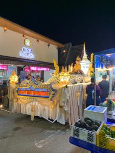 拜县บ้านใจแปงโฮมสเตย์ Ban Jaipang Homestay的夜里，一条龙在市场前漂浮。