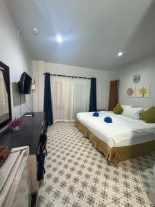 a hotel room with a large bed and a television at Krabi Nemo House in Ao Nang Beach
