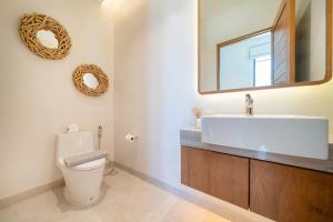 a bathroom with a toilet and a sink and a mirror at Bougainvillea Luxury Pool Villas in Ban Pak Lak +35 photos