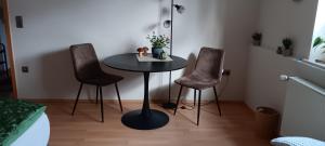 a small table and two chairs in a room at Ferienappartment Schneiderbanger in Bad Wildungen