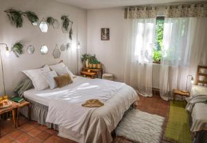 a bedroom with a large white bed and a window at Gîte de plain-pied sans escaliers, Dordogne in Firbeix