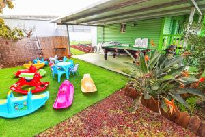 a backyard with childrens play equipment on the grass at אגם בגליל -וילה ו-3 סוויטות מקסימות למשפחות עם בריכה מחוממת in Wadi Keren