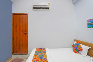 a bedroom with a bed and a window and a door at FabHotel Super Corridor 
