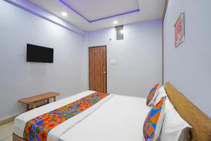 une chambre avec un lit et une télévision au mur dans l'établissement FabHotel Super Corridor, 