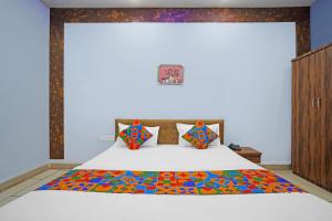 une chambre avec un grand lit avec une couverture colorée dans l'établissement FabHotel Super Corridor, 