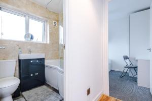 a bathroom with a toilet and a sink and a tub at Middleton 4 Bed Free Parking Long stays in Middleton