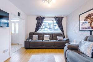a living room with a couch and a window at Middleton 4 Bed Free Parking Long stays in Middleton
