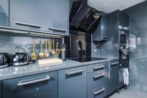 a kitchen with blue cabinets and utensils at Middleton 4 Bed Free Parking Long stays in Middleton +45 photos