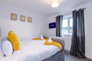 a bedroom with a bed and a window at Middleton 4 Bed Free Parking Long stays in Middleton