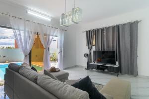 a living room with a couch and a television at Peaceful Villa by Oceanaxe Holidays in Grand Baie