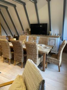 a dining room with a wooden table and wicker chairs at L'armorique in Saint Die